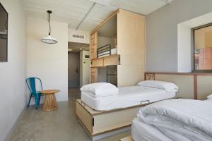 巴塞罗那Unite Hostel Barcelona的一间卧室配有两张床、一张桌子和一把椅子