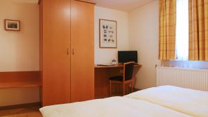 考布德意志豪斯酒店 的一间卧室配有一张床和一张带电脑的书桌