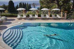 陶尔米纳Grand Hotel Timeo, A Belmond Hotel, Taormina的游泳池,有人躺在水里