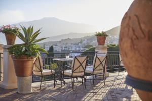 陶尔米纳Grand Hotel Timeo, A Belmond Hotel, Taormina的阳台的天井配有桌椅