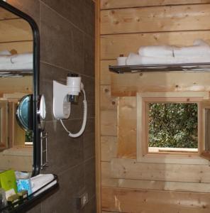 VilledubertLes Cabanes Dans Les Bois Logis Hôtel的浴室设有镜子、水槽和窗户