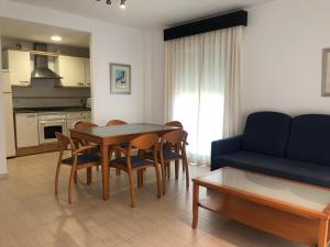 德尼亚拉里维埃拉公寓的客厅配有桌椅和沙发
