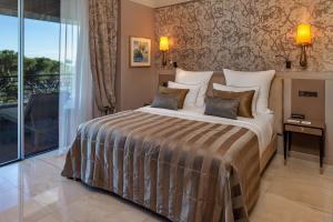 萨卡罗Alàbriga Hotel & Home Suites GL的一间卧室设有一张床和一个大窗户