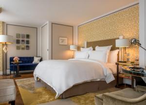 巴黎巴黎瑰丽酒店的一间卧室配有一张大床和一张蓝色的沙发