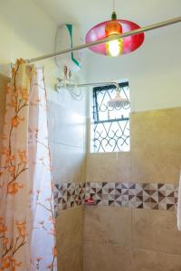 蒙巴萨Serene Homes的带淋浴帘和窗户的浴室
