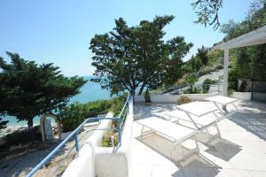 马蒂纳塔case vacanza montesaraceno的阳台配有白色椅子,享有海景。