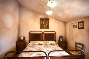 Cineto RomanoLocanda della Casella的卧室配有一张床,墙上挂有绘画作品