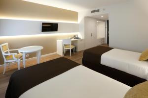 卡塔赫纳塞尔科蒂尔阿方索十三世酒店的酒店客房设有两张床和一张桌子。