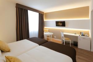 卡塔赫纳塞尔科蒂尔阿方索十三世酒店的配有一张床和一张书桌的酒店客房