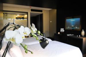 阿莫拉艾维登西亚比华迪酒店的一间酒店客房,床上摆放着白色的鲜花