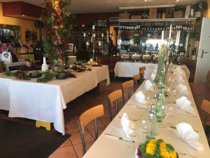 梅尔斯堡Hotel Bacchus Wine & Bites的餐厅的一排桌子,有白色桌布