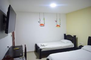 巴兰基亚国际套房宾馆的客房设有两张床和一台平面电视。