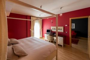 萨拉曼卡Itaca Salamanca by Soho Boutique的一间卧室设有红色的墙壁、一张床和一张书桌