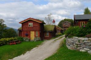 RendalenRomenstad Hytter的土路上有草屋顶的房子