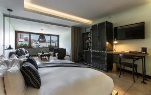 麦德林查理酒店的卧室配有一张白色大床和一张书桌