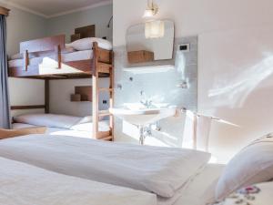 圣维吉利奥Rifugio Graziani Hütte的一间卧室设有两张双层床和水槽