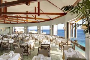 Southampton珊瑚礁俱乐部度假村的餐厅设有桌椅,以大海为背景