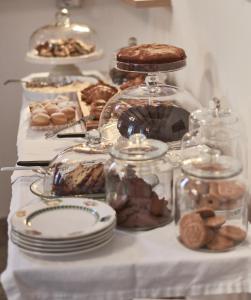 卡塞塔卡瑟迷人酒店的一张桌子,上面放有盘子和罐子的饼干和蛋糕