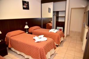 科连特斯Hotel Confianza的酒店客房,配有三张床和毛巾