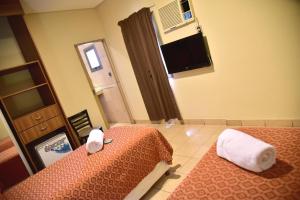 科连特斯Hotel Confianza的酒店客房设有两张床和电视。