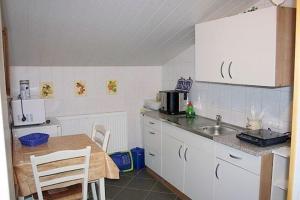 普特布斯One-Bedroom Apartment in Putbus II的厨房配有白色橱柜、桌子和水槽。