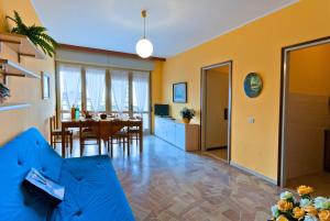 比比翁Apartment in Bibione 24425的客厅和带蓝色沙发的用餐室