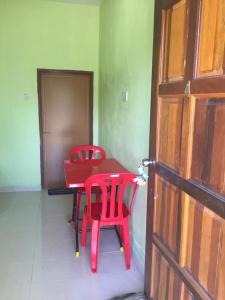 关丹Santai Lots Cherating的红色桌子和椅子,位于带门的房间