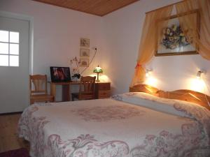 库雷萨雷海伦旅馆的一间卧室配有一张床、一张书桌和一个窗户。