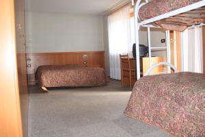 卡瓦莱塞加尼格西亚金色酒店的一间卧室配有两张床和一张双层床。