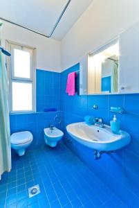 比比翁Apartments in Bibione 25584的蓝色的浴室设有水槽和卫生间