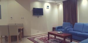 阿可贺巴Mani VIP Suites的客厅配有2把蓝色椅子和电视