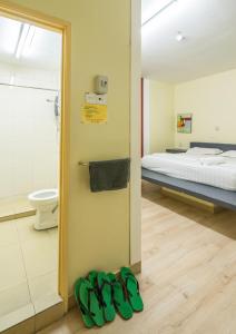 怡保河畔修道院酒店的一间房间,配有一张床和一双绿鞋