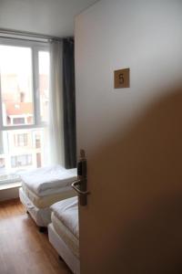 布鲁塞尔腓特烈斯贝酒店的一间设有两张床的房间和一扇门,门的号码