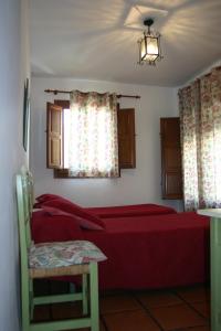 布维翁拉斯维加斯特拉萨斯德拉阿尔普哈拉乡村旅馆的一间卧室设有红色的床和窗户。
