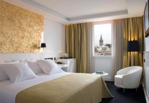 塞维利亚Hotel Colón Gran Meliá - The Leading Hotels of the World的酒店的客房 - 带一张床、椅子和窗户