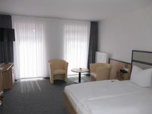 克洛彭堡Hotel Diekgerdes, Komfortzimmer的酒店客房带一张床、一张桌子和椅子