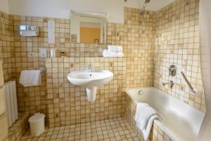 勒布朗-梅尼尔Cit'Hotel Aéro-Hotel的浴室配有盥洗盆和浴缸。