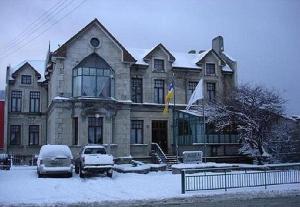 蓬塔阿雷纳斯雷伊豪尔赫岛酒店的一座大房子,里面装有汽车停放在雪中