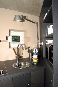 RottAu Bunker 67的厨房配有水槽和台面上的灯