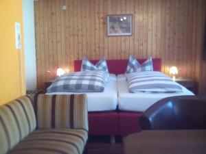 巴特维尔德巴德恩特拉奇特酒店的一张带蓝色和白色枕头的床和一张沙发
