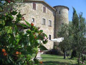 古比奥Agriturismo Castello Di San Vittorino的一座大型石头建筑,上面有一座塔