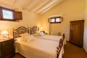 科尔托纳Borgo Solamore的一间卧室设有两张床、一张桌子和两个窗户。
