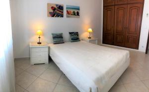 阿尔图拉Apartamento Praia Altura - Terraço BBQ - Wifi - AC - Garagem Fechada的一间卧室配有一张带两盏灯的大型白色床。