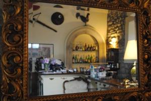 古比奥Agriturismo Castello Di San Vittorino的镜子反射在房间里酒吧的镜子