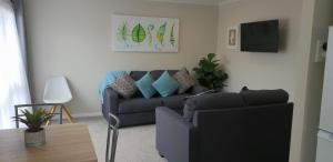 罗托鲁瓦Rose Apartments Unit 6 Central Rotorua-Accommodation & Spa的客厅配有沙发和桌子