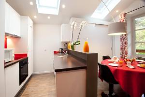 芒通圣贝尔纳萨瓦亚赫德—奢华享受公寓的厨房配有红色台面的桌子