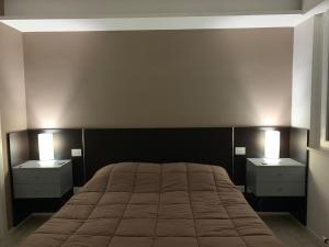 安科纳Il Parco Di Yuki (2)的一间卧室配有一张带2个床头柜的大床