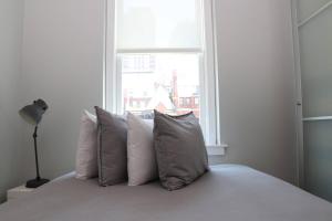 波士顿Comfortable Studio in Back Bay, Newbury St. #7的卧室配有带枕头的床铺和窗户。