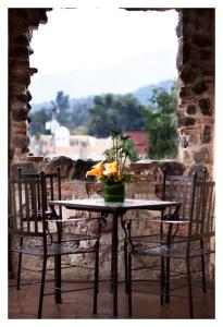 危地马拉安地瓜Meson de Maria的一张桌子,两把椅子,花瓶上放着鲜花