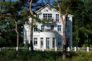 赛巴特班森Villa Desny的前面有树木的白色房子